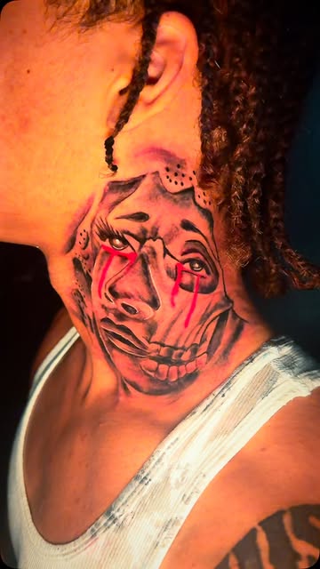 Black and grey portrait tattoo on the side of a neck